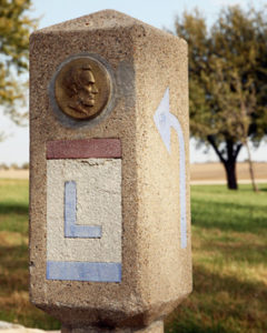 Lincoln Highway Marker with an Abraham Lincoln Medallion and red, white, and blue Lincoln Highway logo