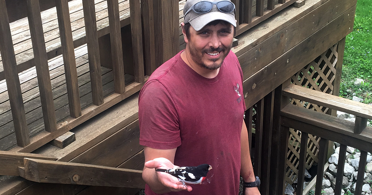 Chris Barber holding a rose-breasted grosbeak at the Calkins Nature Area.