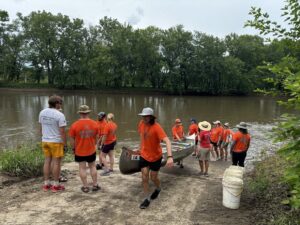 Volunteers unload trash-filled canoes at last year's Project AWARE