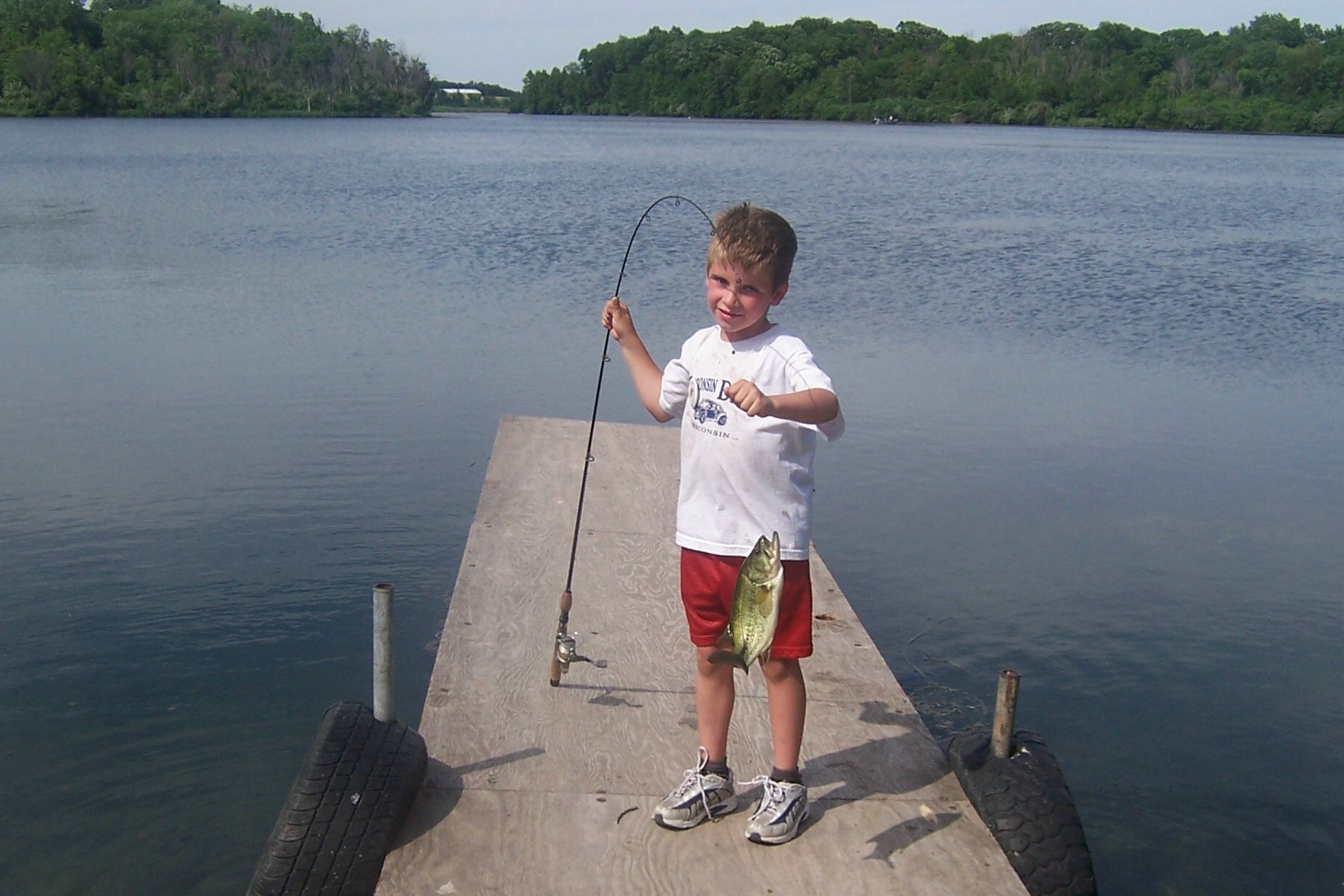 A boy catches a bass at Briggs Woods Lake.